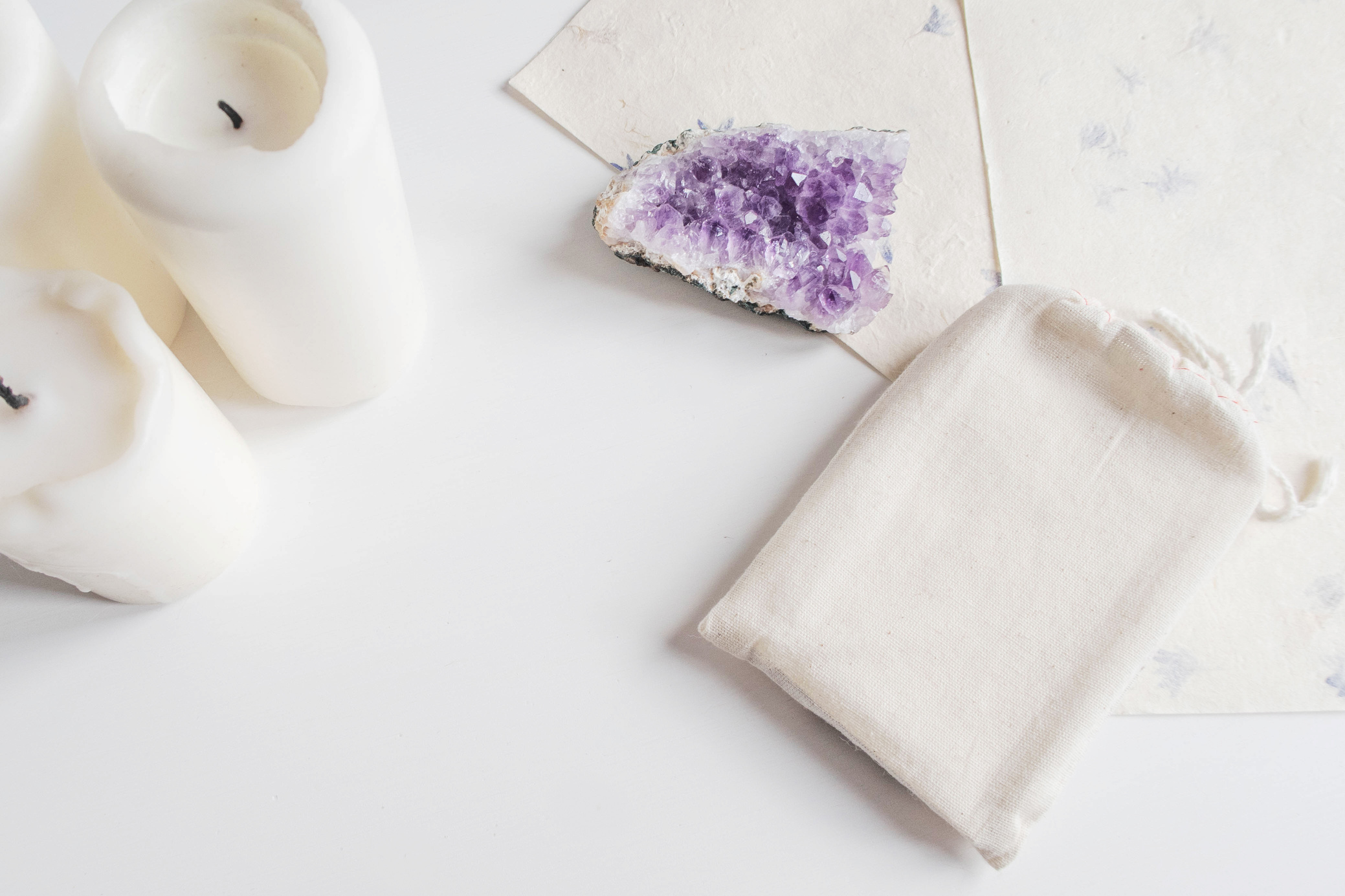 Mock up of tarot deck cotton bag, amethyst and candles on white background. Boho design of tarot cards pouch on white table